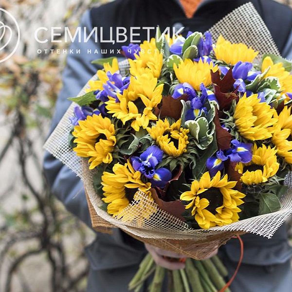 Букет из подсолнухов, ирисов и гиперикума в упаковке